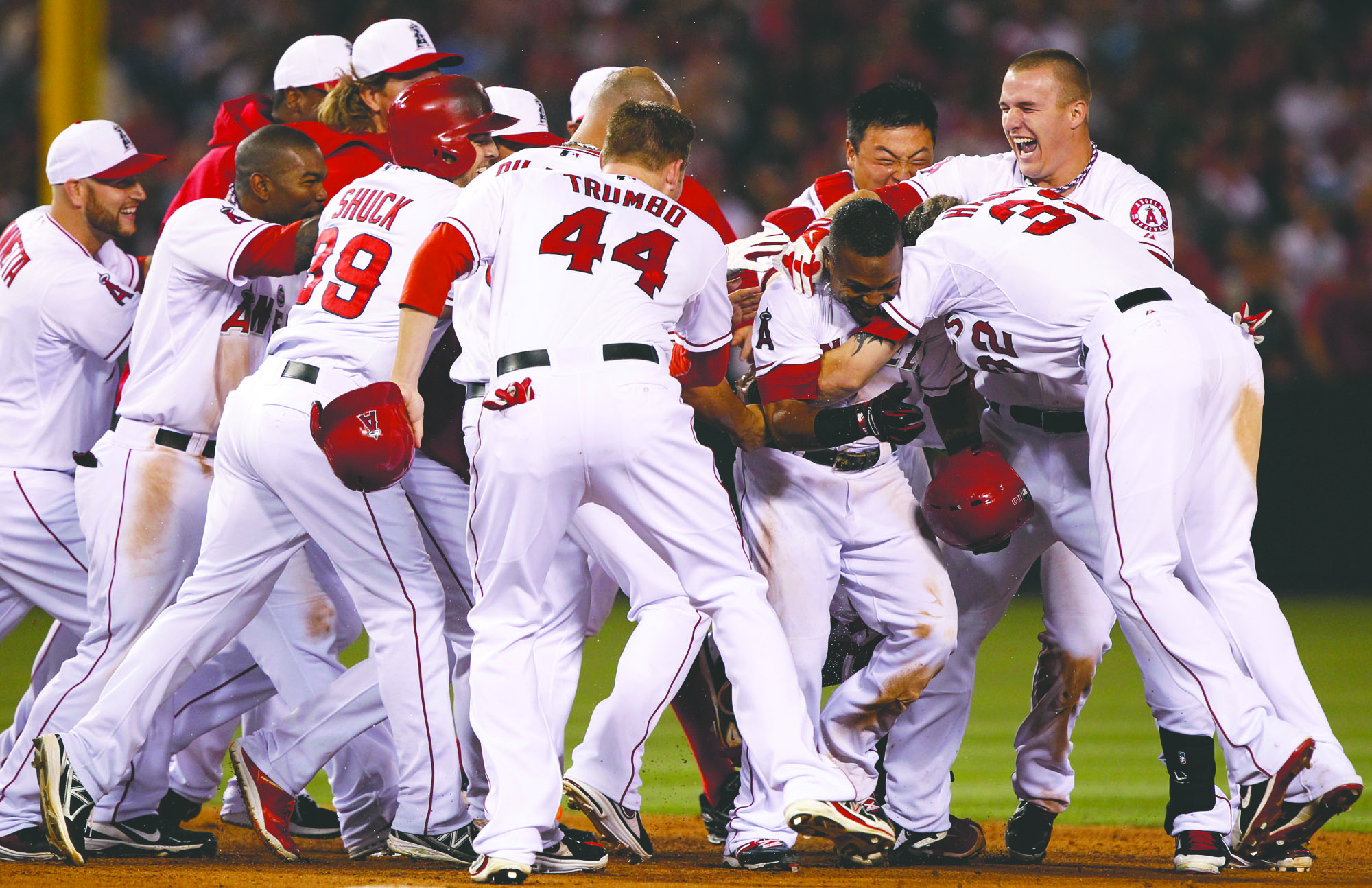 Associated Press Los Angeles Angels' Erick Aybar, center, is mobbed by teammates after hitting the game-winning single against the St. Louis Cardinals in the ninth inning Thursday in Anaheim, Calif. The Angels won the game 6-5.